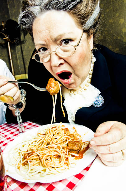 spaghetti - eating senior adult color image spaghetti photos et images de collection