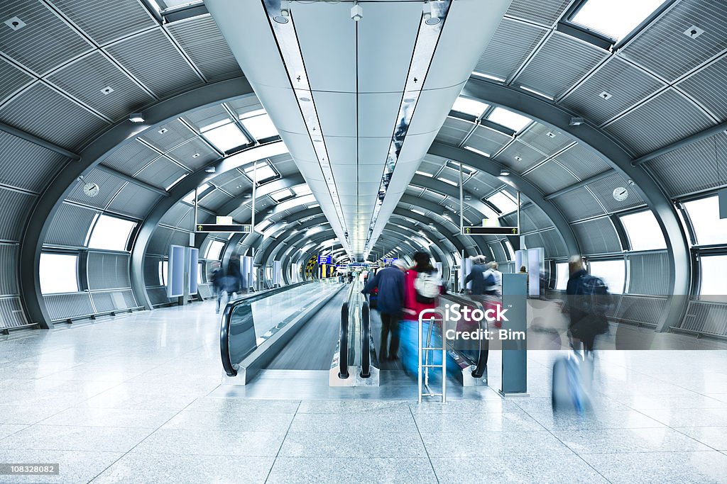 Flughafen-Tunnel mit verschwommene Passagiere auf Rollender Bürgersteig - Lizenzfrei Flughafen Stock-Foto