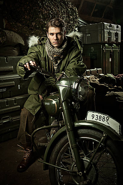 Jovem homem em uma moto militar vintage - foto de acervo