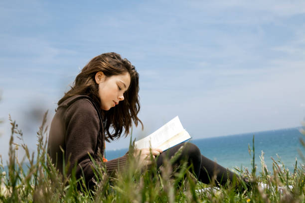 Child reading poetry by the sea