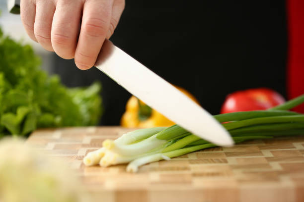 Cook holds knife in hand and cuts on