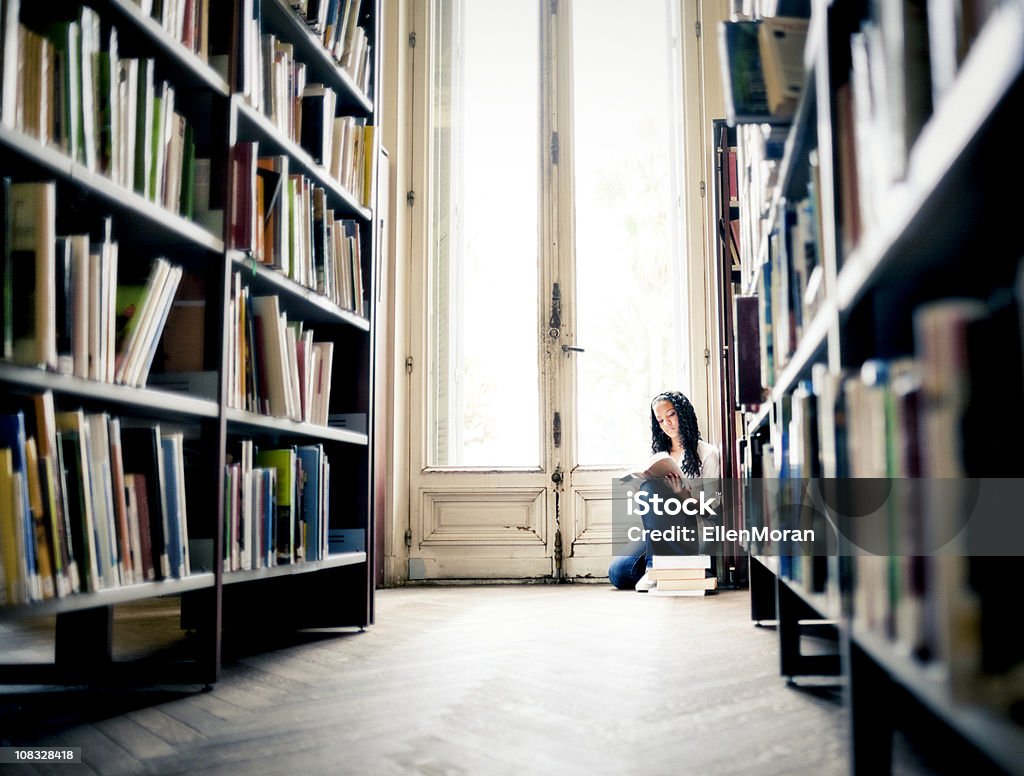 Подросток чтение в библиотеке - Стоковые фото Библиотека роялти-фри