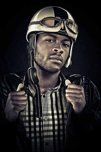 young black guy wearing a vintage motorcycle helmet looking at camera with an attitude.