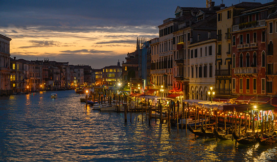 View from Rialto Bridge over illuminated Grand Canal at dusk in Venice, Italy