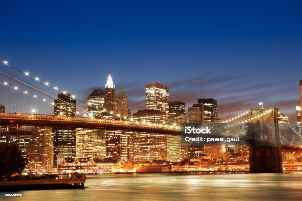 Manhattan, NYC Brooklyn bridge with Manhattan buildings in background by night Architecture Stock Photo