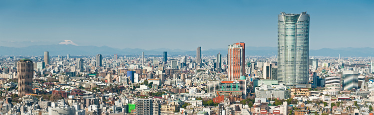 The iconic perfect snow capped cone of Mount Fuji (3776m) rising from the Chubu highlands to look over the downtown city blocks, soaring skyscrapers and crowded towers of central Tokyo, Japan's sprawling mega-city capital, from the low rise suburbs to the massive shiny edifice of Roppongi Hills in this large and detailed rare panoramic vista. ProPhoto RGB profile for maximum color fidelity and gamut.\n\n[b]See more great images of Tokyo, Japan in this lightbox:[/b]\n\n[url=http://www.istockphoto.com/search/lightbox/8025848][img]http://www.fotovoyager.com/istock/lightbox_tokyo.jpg[/img][/url]\n\n[b]See many more great panoramic images here:[/b]\n\n[url=http://www.istockphoto.com/search/lightbox/384048][img]http://www.fotovoyager.com/istock/lightbox_panoramas.jpg[/img][/url]