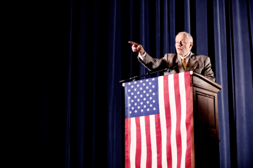 Politician speaking at a political rally, European Union flag in background