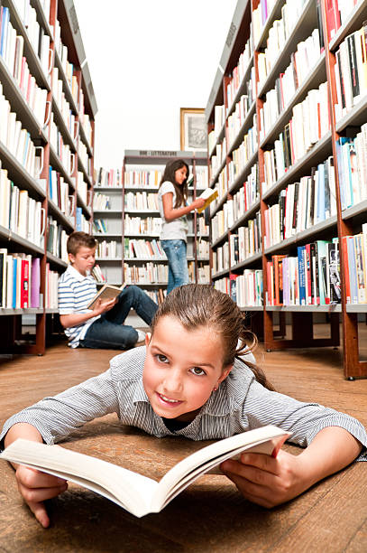 istock Little Girl Reading in Library 108328887