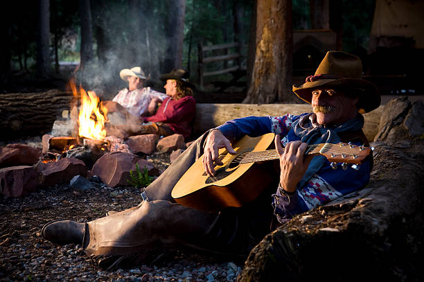 istock Cowboys around fire in woods with guitar 108328892