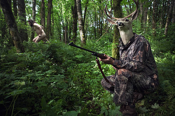 Role Reversal Deer Hunter A deer with a rifle in camouflaged clothing hunts a wild naked man in a green forest. Oh the irony. deer hunting humor stock pictures, royalty-free photos & images