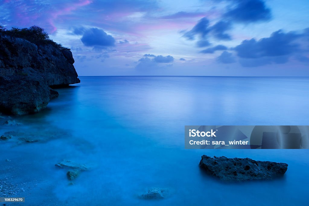 Rocky coast nell'isola di Curaçao al crepuscolo - Foto stock royalty-free di Acqua