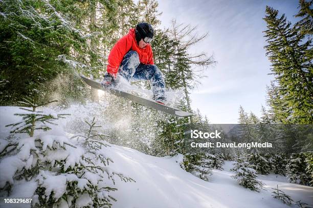 Snowboarder Saltar En El Bosque Foto de stock y más banco de imágenes de Tabla de snowboard - Tabla de snowboard, Bosque, Deporte