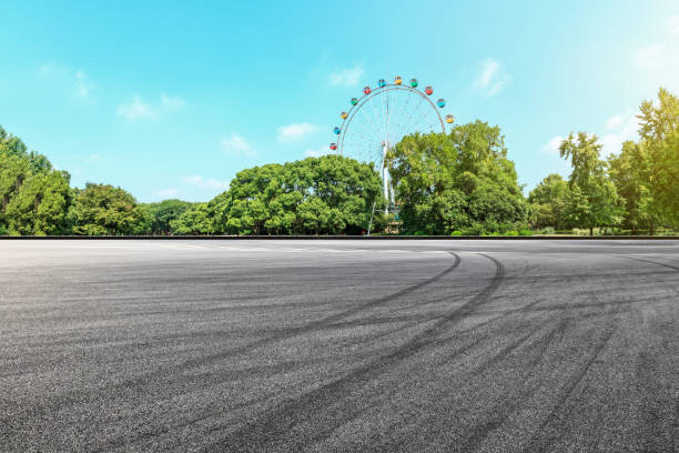 istock Asphalt square road and ferris wheel with green forest landscape 1083298236
