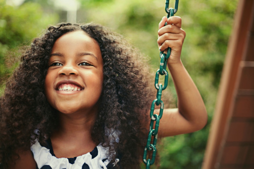 young girl on a swing smiling