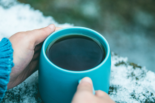 Woman holding cup of coffee in winter