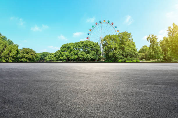 istock Asphalt square road and ferris wheel with green forest landscape 1083300908
