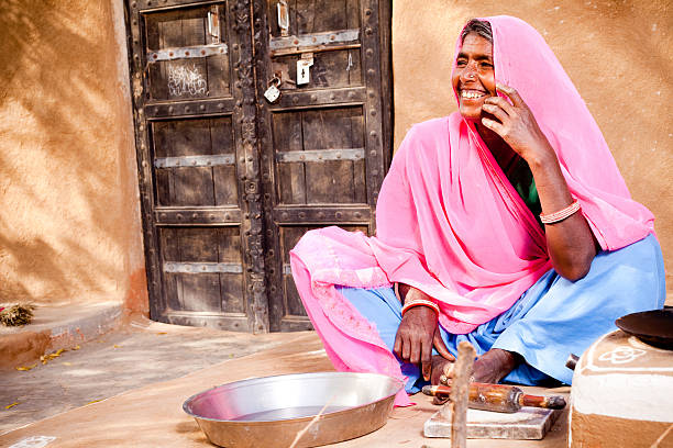 rajasthan in india rurale donna preparare il cibo - looking at camera full length outdoors image technique foto e immagini stock