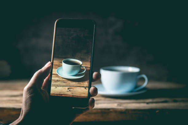 Photographing cup of coffee with phone