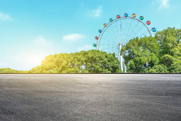 istock Asphalt square road and ferris wheel with green forest landscape 1083304412