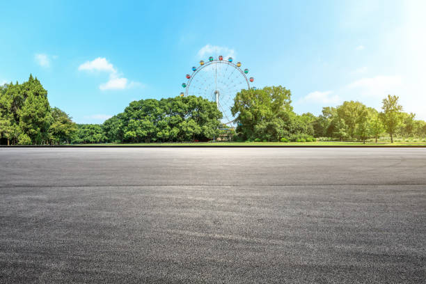 istock Asphalt square road and ferris wheel with green forest landscape 1083304794