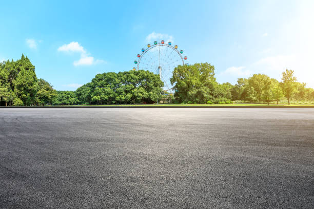 istock Asphalt square road and ferris wheel with green forest landscape 1083305330