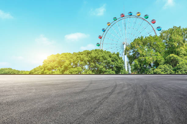 istock Asphalt square road and ferris wheel with green forest landscape 1083306862