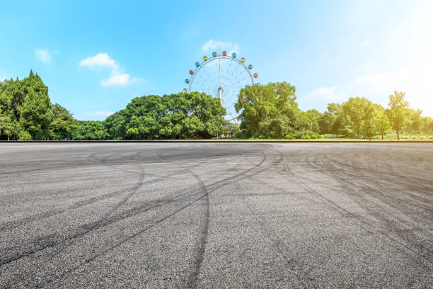 istock Asphalt square road and ferris wheel with green forest landscape 1083306866
