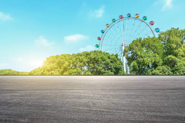 istock Asphalt square road and ferris wheel with green forest landscape 1083307266