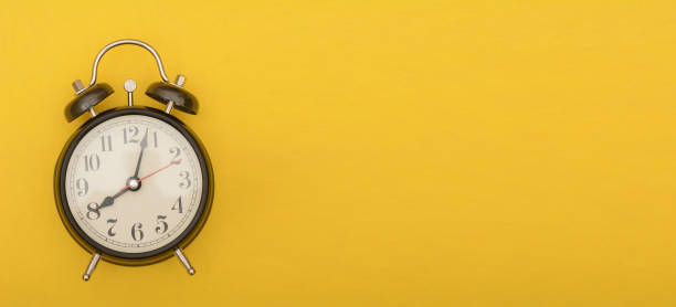 istock Analog alarm clock on yellow color background, timing theme 1083309188