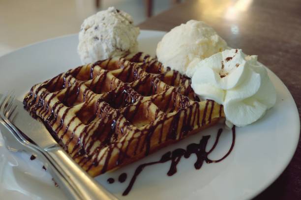 istock Waffle and vanilla ice cream in white plate on wooden table 1083309436