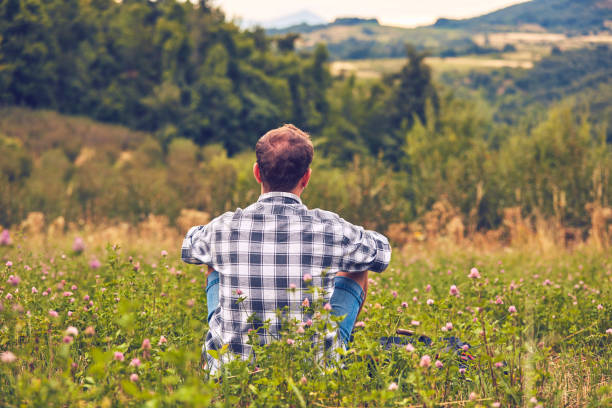 Man taking a break in nature and looking at the distant landscape.