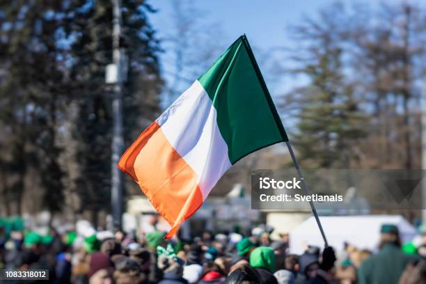 Flag Of Ireland Closeup In Hands On Background Of Blue Sky During The Celebration Of St Patricks Day Stock Photo - Download Image Now