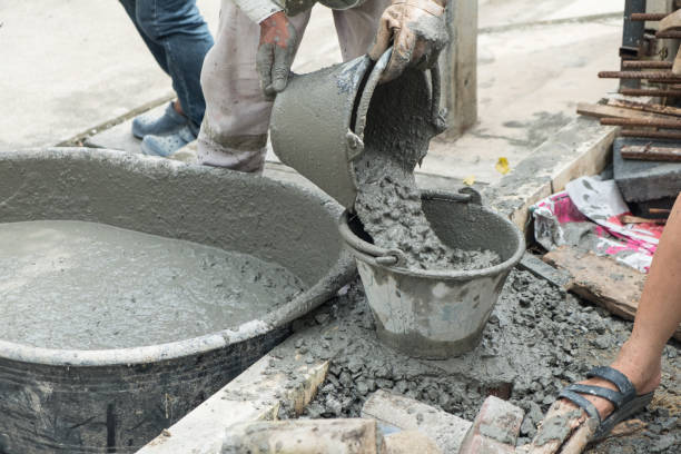 istock Worker pouring cement mix concrete in bucket at a construction site. 1083318168
