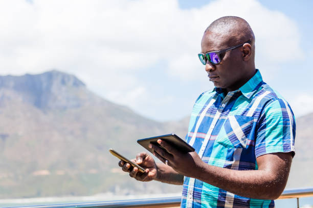 istock African guy texting on his tablet pc and smartphone 1083319158