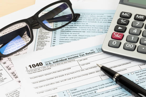 istock Tax form with glasses, and calculator 1083320886