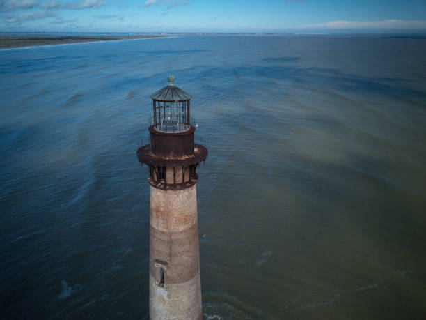 imagem aérea do zangão do histórico farol ilha morris na entrada para a entrada do porto de charleston south carolina - charleston harbor - fotografias e filmes do acervo