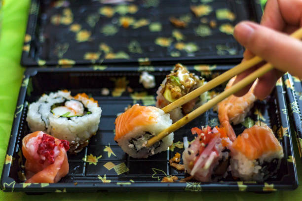 istock Chopsticks taking portion of sushi roll 1083329210