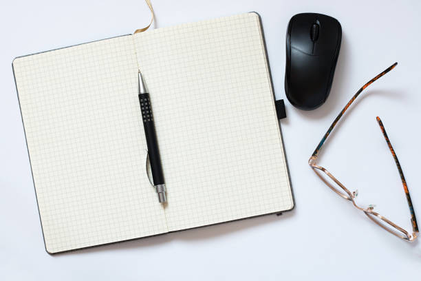 Office table with notebook, Pen, mouse, eyeglasses on white background. Desktop office mockup concept