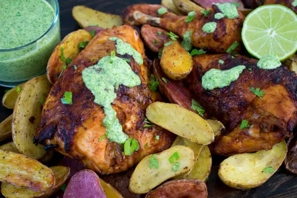 Roasted chicken drizzled with aji verde sauce and garnished with lime