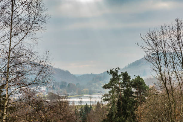 beautiful panoramic view of the Doyards Lake in Vielsalm view from a hill on a wonderful, cloudy and cold autumn day with sunbeams reflecting in the lake in the Belgian Ardennes