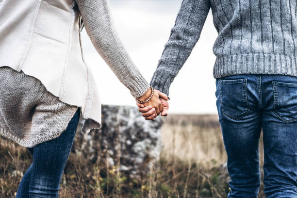 Pretty young couple in love outdoor Photo of romatic couple hands, walking outdoor and spending time together couple holding hands stock pictures, royalty-free photos & images
