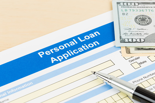 Personal loan application form with dollar money banknote, and pen