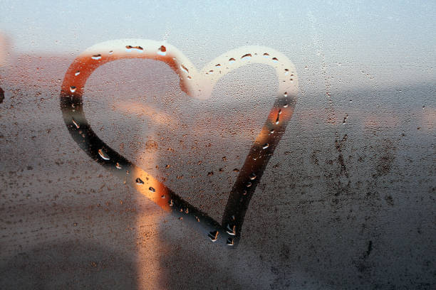 istock Heart painted on the wet window glass. 1083346698