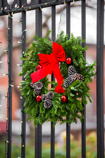 Wrought iron church gate decorated with wreath and lights for Christmas