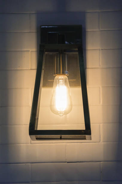 istock Square steel lamp tungsten/warm light on the white brick wall. 1083351988