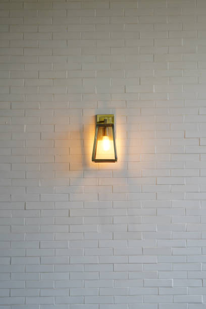 istock Square steel lamp tungsten/warm light on the white brick wall. 1083352006