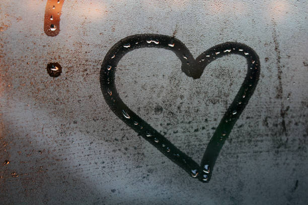 istock Heart painted on the wet window glass. 1083354076