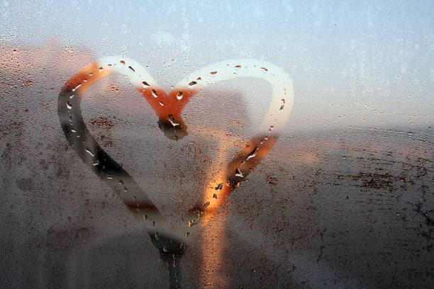istock Heart painted on the wet window glass. 1083354392