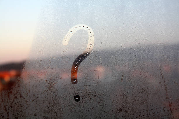 Question mark painted on the wet window glass