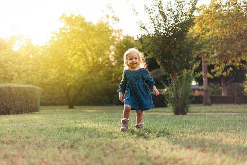Portrait of a beautiful little girl playing in a public park. Horizontal composition.